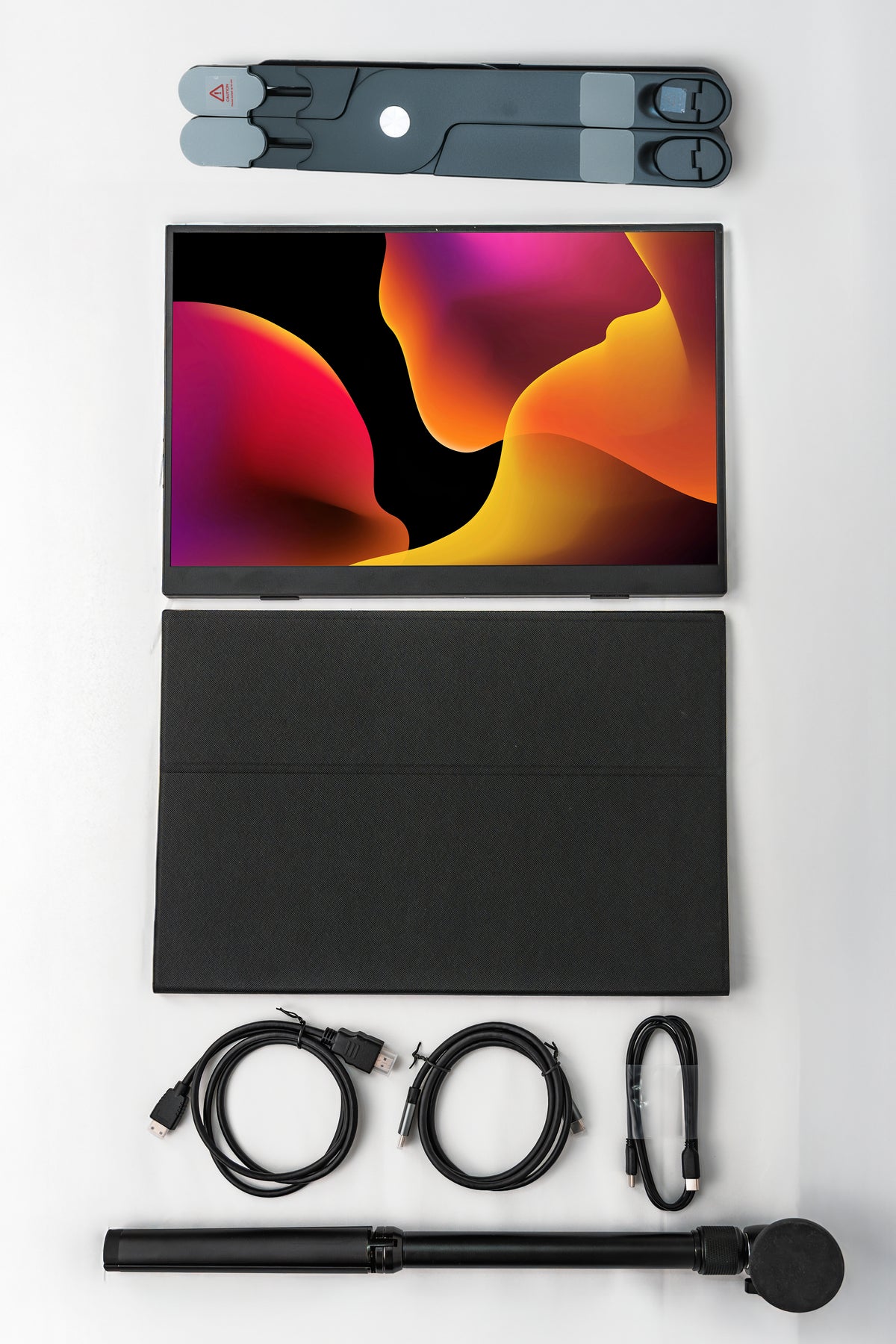 A flat-lay product presentation of a black tablet with a matching protective cover, shown with its accessories including a stylus, cables, and a folded screen protector on a clean white background.